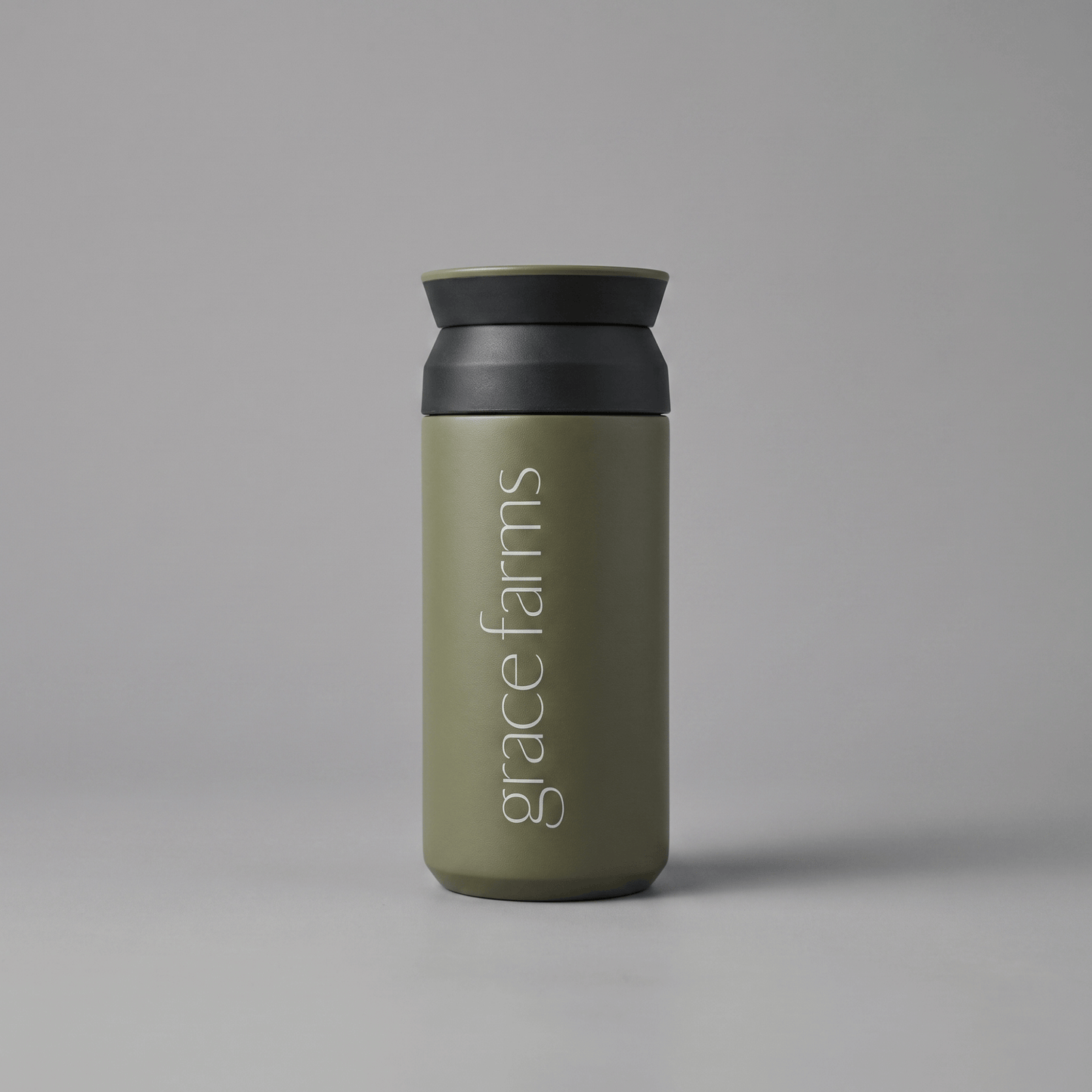 KINTO travel tumbler in khaki, featuring the vertical white text 'grace farms' on the front, set against a solid gray background.