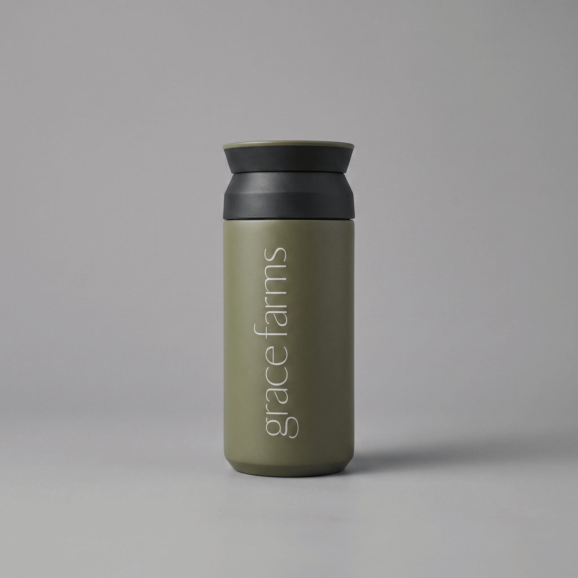 KINTO travel tumbler in khaki, featuring the vertical white text 'grace farms' on the front, set against a solid gray background.