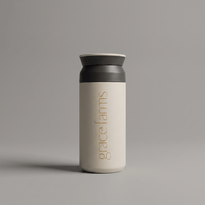 KINTO travel tumbler in white, featuring the vertical white text 'grace farms' on the front, set against a solid gray background.