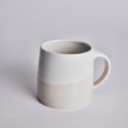 White & pink ceramic KINTO mug on a light gray background